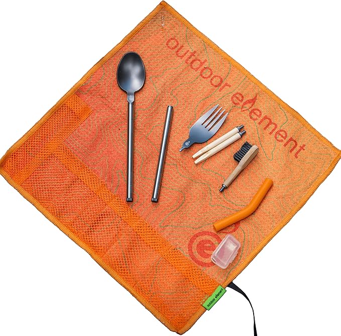 Omni-Tensil modular camping utensil kit on orange roll towel with fork, spoon, chopsticks, toothbrush and bellows
