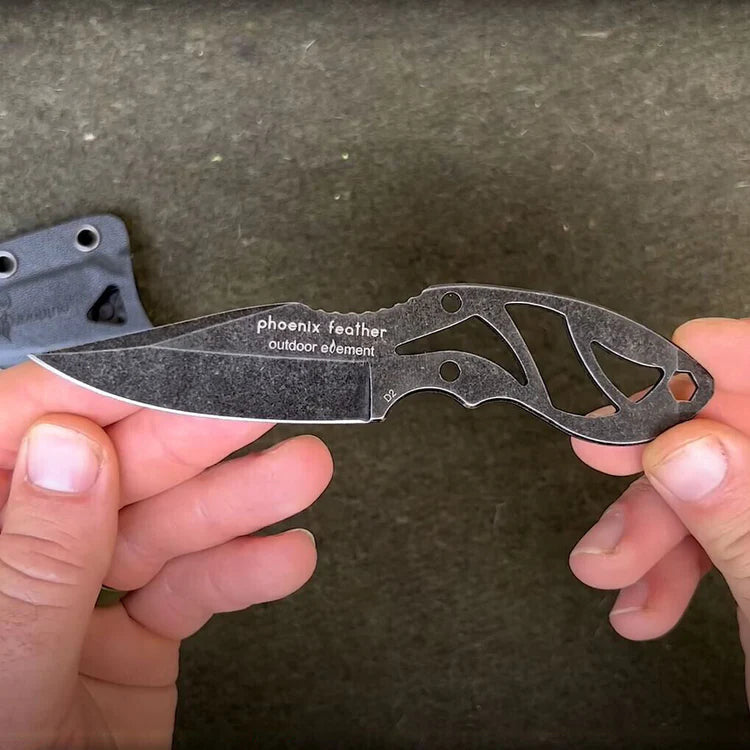 Folding knife with 'phoenix feather outdoor element' branding held by a person against a dark background