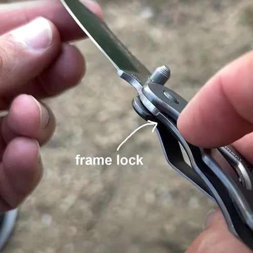 Folding knife with frame lock mechanism held by a person, blurred background