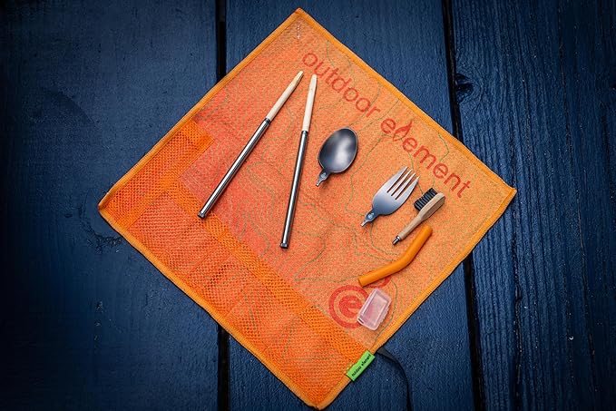 Orange mesh pouch with outdoor utensils on a dark wooden surface